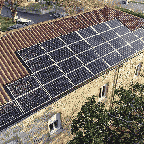 Maison en pierre avec toit en tuile équipé de panneaux solaires, fusion d'architecture traditionnelle et de technologie moderne