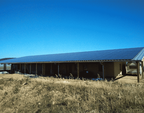 Grange moderne couverte de panneaux solaires dans un champ ensoleillé
