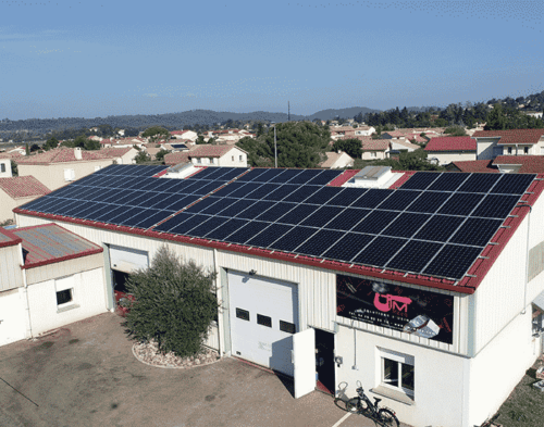 Complexe industriel avec toiture solaire photovoltaïque dans un quartier résidentiel