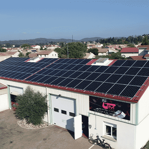 Vue aérienne d'un bâtiment industriel avec une installation de panneaux solaires photovoltaïques sur le toit