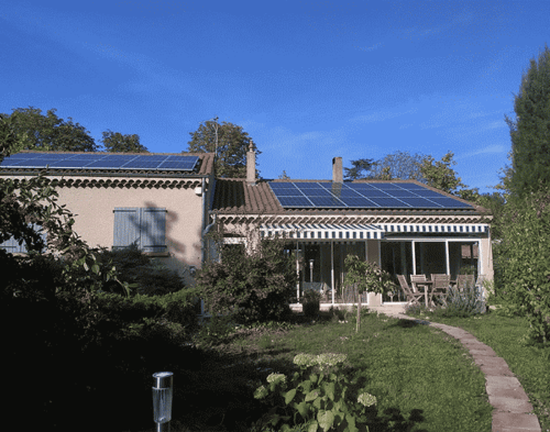 Maison résidentielle avec jardin verdoyant et panneaux solaires sur le toit