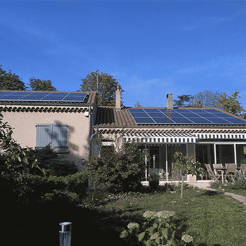 Panneaux solaires modernes sur le toit d'une maison durable avec jardin